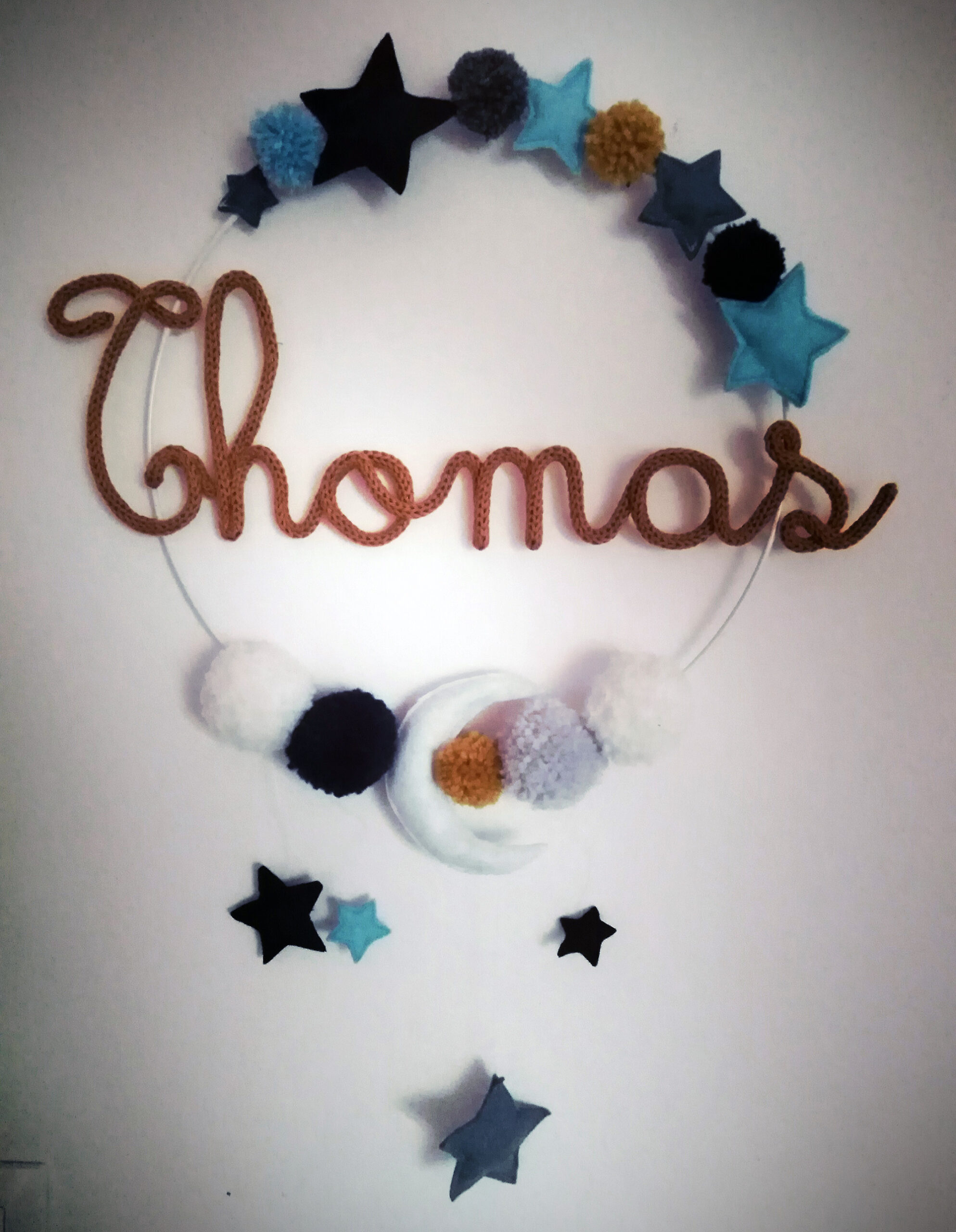 Thomas en tricotin sur une couronne avec des décorations en feutrine