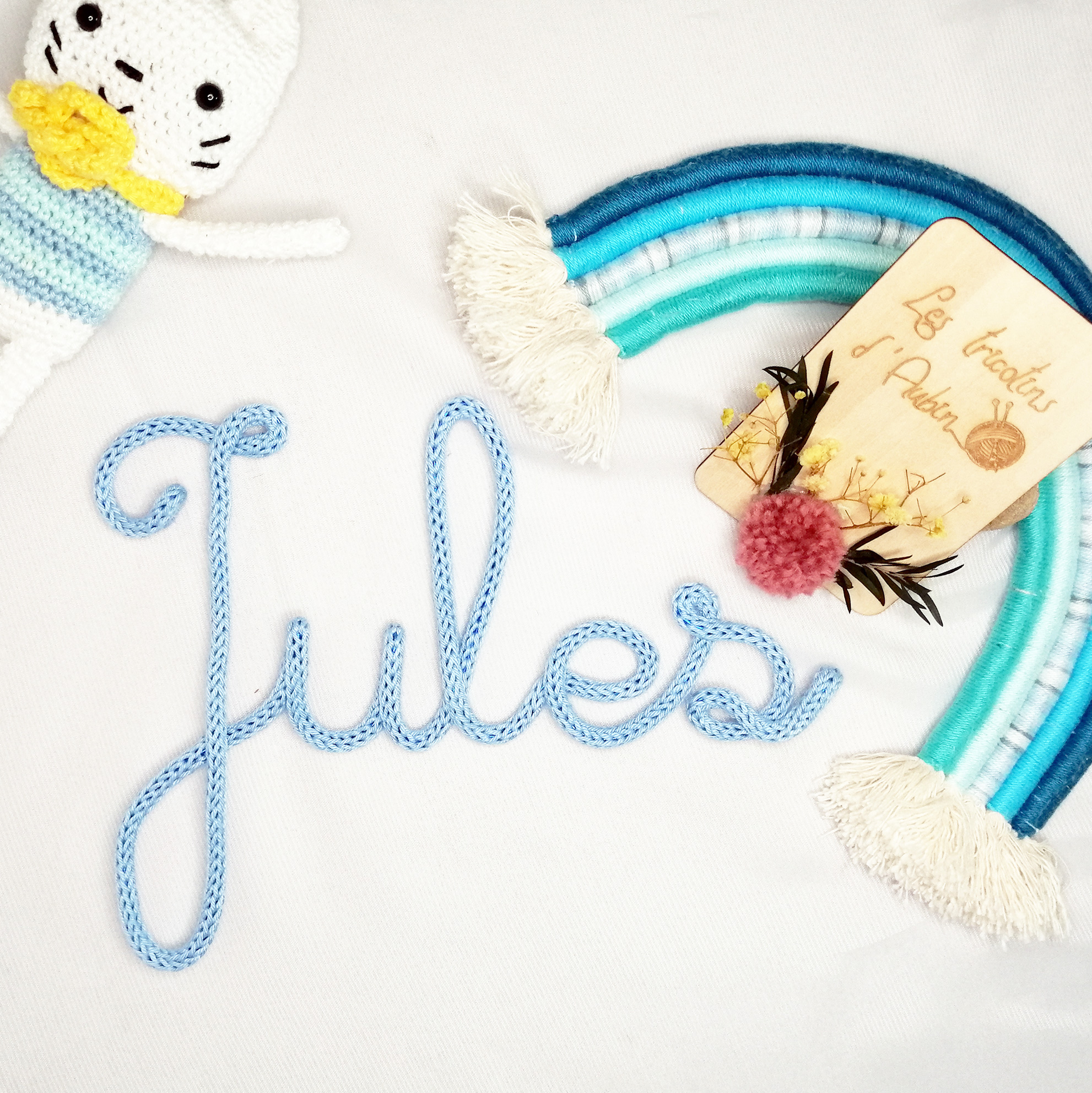 Prénom Jules en tricotin bleu pastel avec un arc-en-ciel en laine