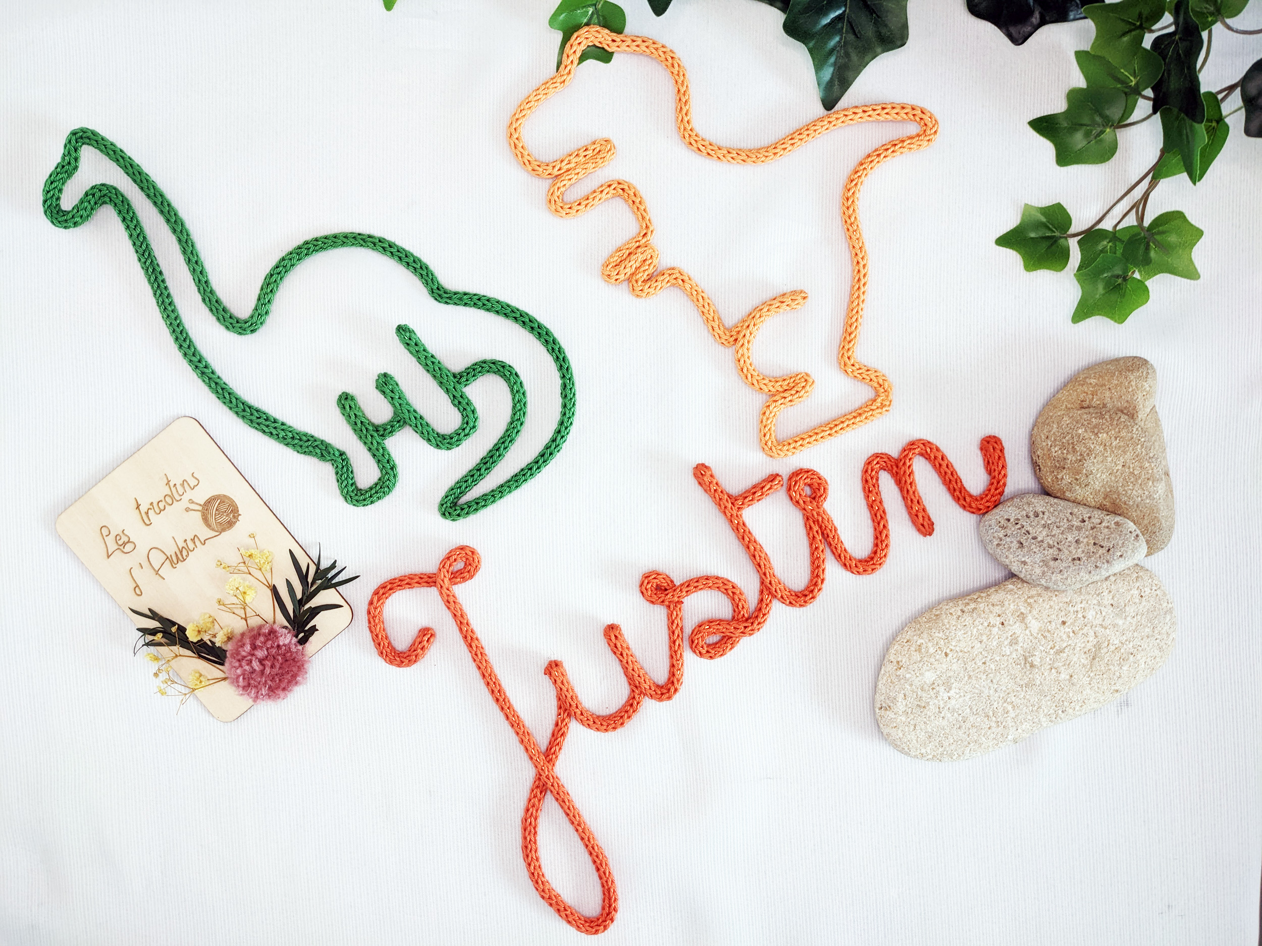 Prénom en tricotin Justin en orange et ses dinosaures vert et moutarde